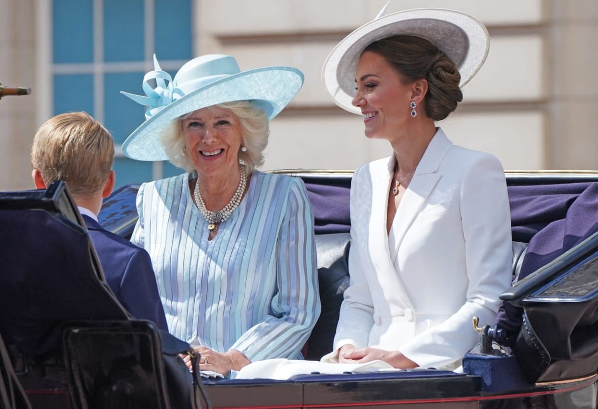 Camilla, vévodkyně z Cronwallu, ve světle modrém proužkovaném modelu a vévodkyně Kate v bílé.