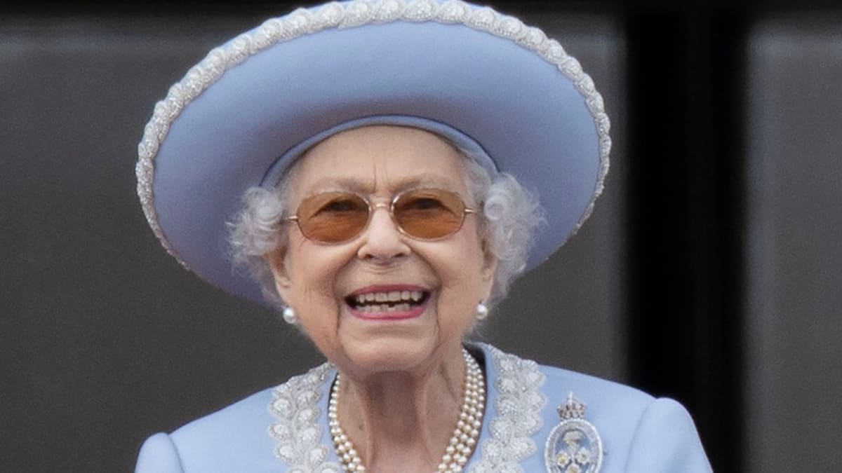 Královna Alžběta II. se na balkoně objevila ve světle modrém kostýmku s jako vždy elegantním kloboukem.