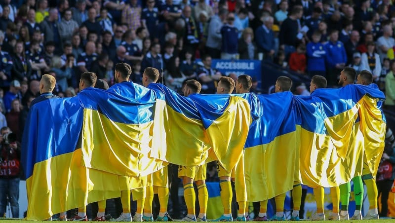 Ukrajinští fotbalisté nakráčeli na trávník před zápasem se Skotskem zabalení do vlajek.