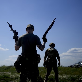 Člen ukrajinské civilní milice drží brokovnici a pušku během výcviku na předměstí Kyjeva