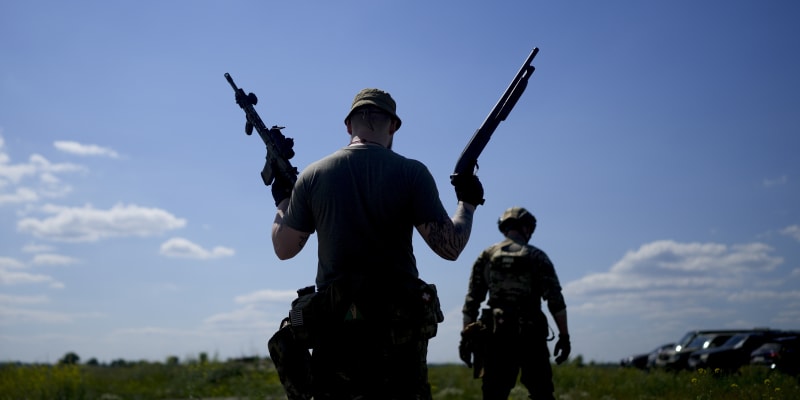 Člen ukrajinské civilní milice drží brokovnici a pušku během výcviku na předměstí Kyjeva.