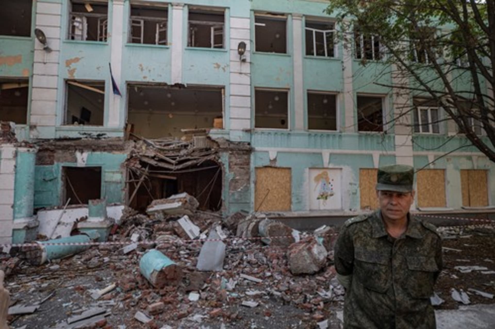 Zástupce velitele milice Doněcké lidové republiky Eduard Basurin stojí před budovou školy v centru Doněcku, kterou poškodilo ostřelování.