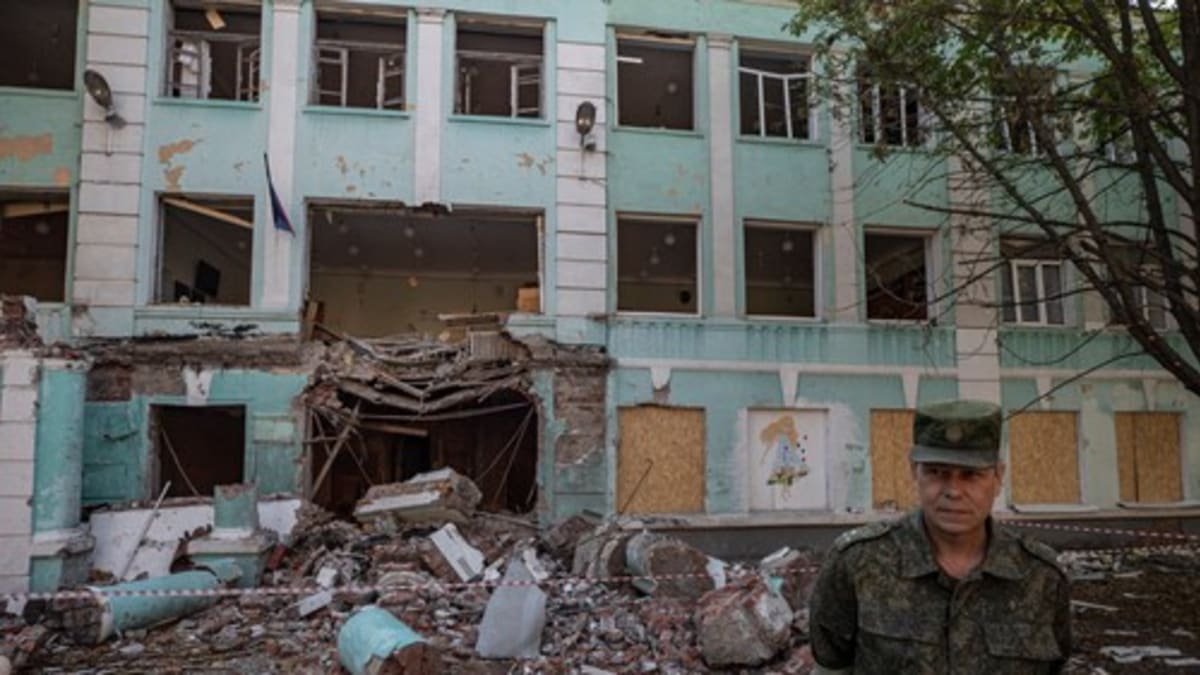 Zástupce velitele milice tzv. Doněcké lidové republiky Eduard Basurin před budovou školy v centru Doněcku, kterou poškodilo ostřelování