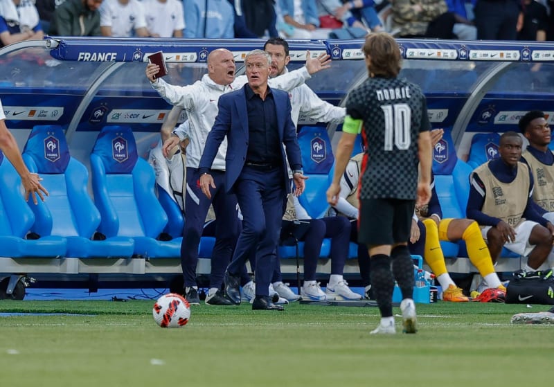 Trenér francouzské fotbalové reprezentace Didier Deschamps (v obleku) pozoruje před zraky chorvatského kapitána Luky Modriče u lavičky výrok rozhodčího v duelu Ligy národů. 