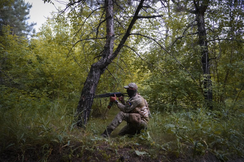 Ukrajinský voják prozkoumává les v Doněcké oblasti.