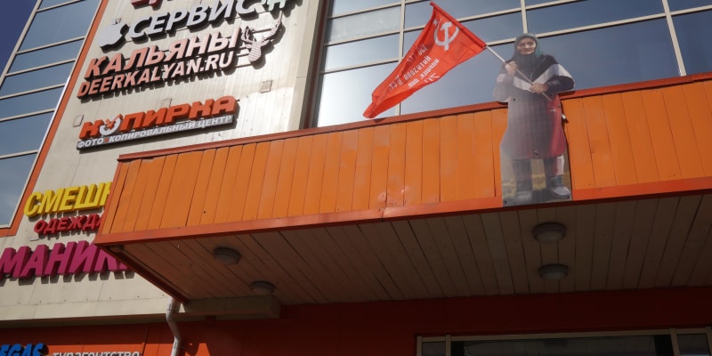 Kartonová postava Babushky Z na fasádě nákupního centra v Moskvě