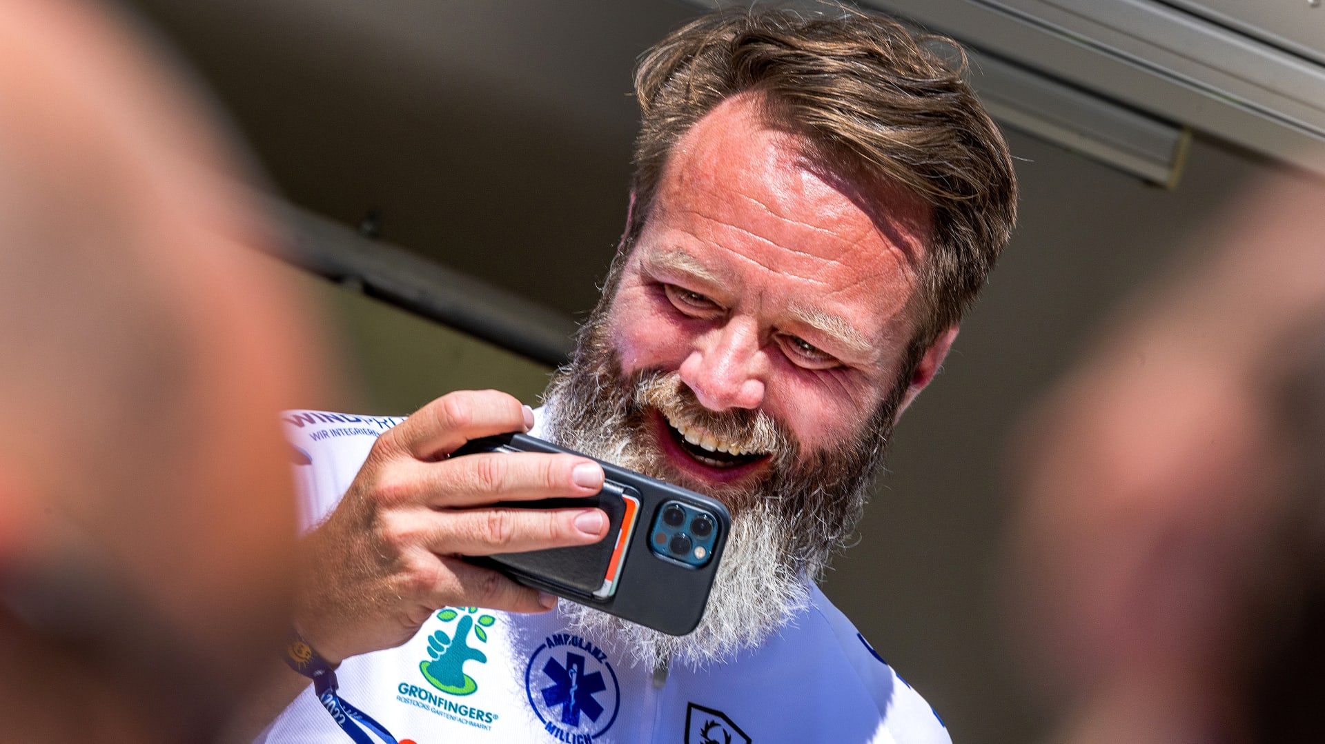 Rodák z dánské Kodaně Claus Ruhe Madsen, který je starostou severoněmeckého města Rostock, natáčí na mobilní telefon účastníky charitativního cyklistického výjezdu na pomoc chronicky nemocným dětem.