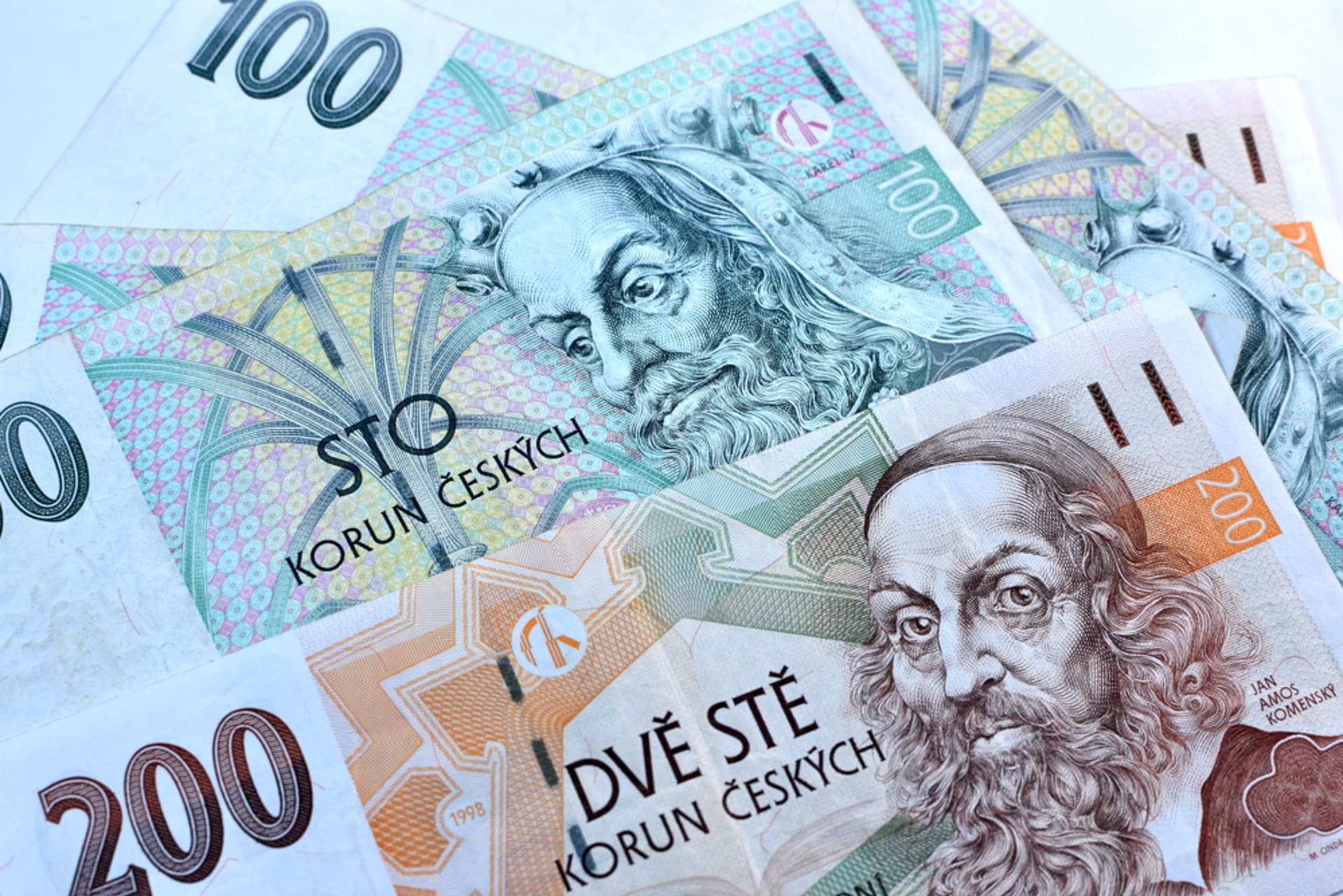 Bankovky v hodnotě 100 a 200 korun, které od 1. července pozbyly své platnosti. Poznáme je například podle příliš úzkého kovového ochranného proužku.