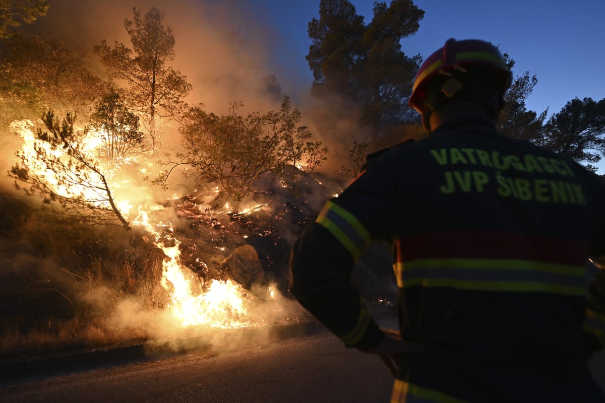 Při velkém požáru nedaleko chorvatského města Šibenik se lidé musejí evakuovat pomocí lodí. Desítkám hasičů pomáhá i armáda.