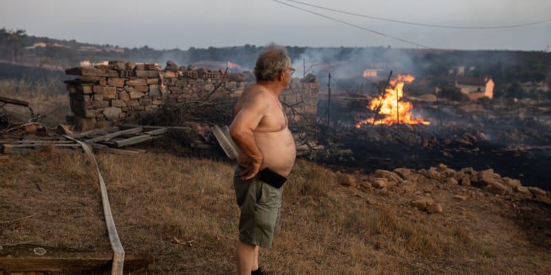 Muž sleduje plameny požáru Losacio 17. července 2022.