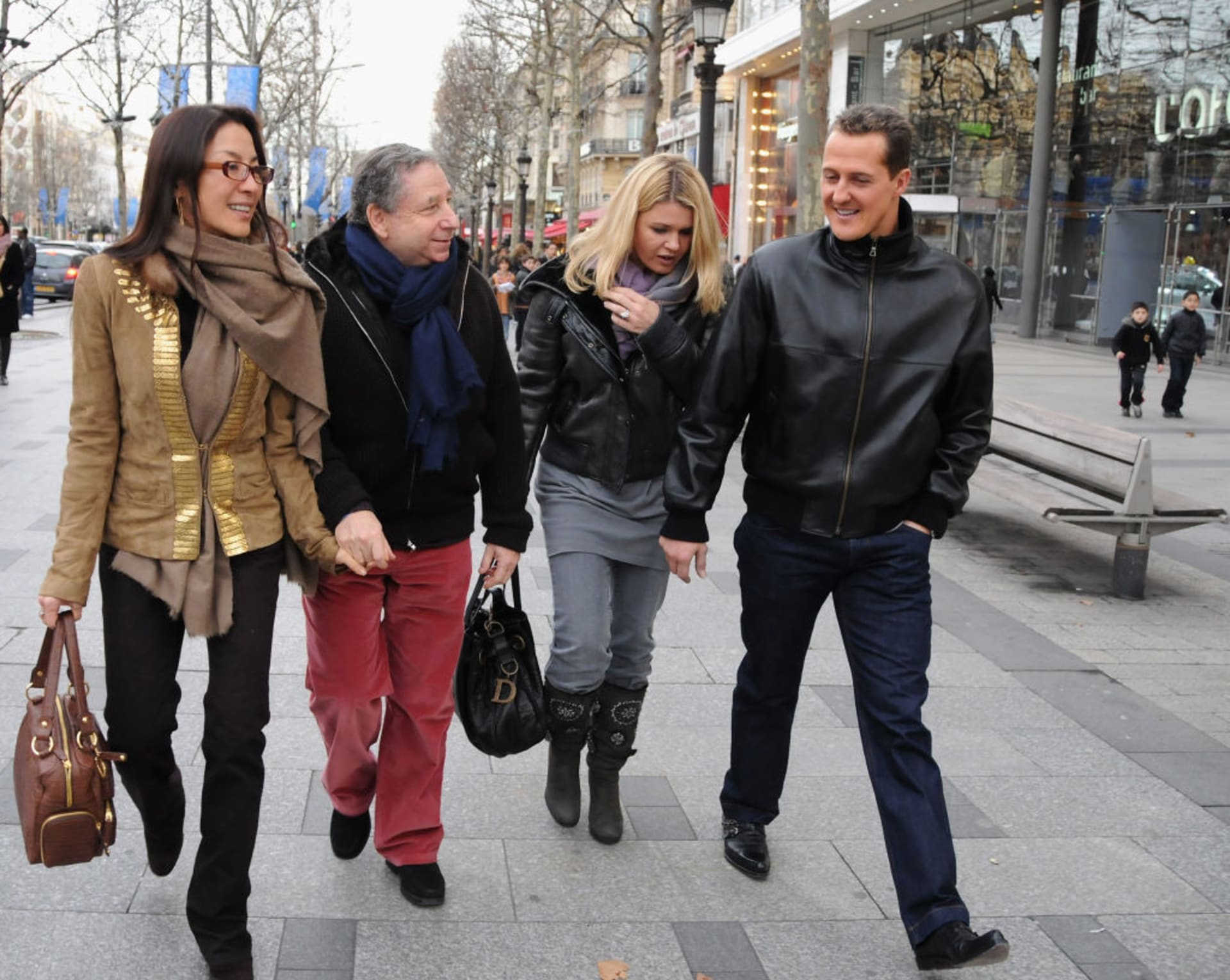 Německý pilot formule 1 Michael Schumacher (vpravo) kráčí se svou manželkou Corinnou, bývalým ředitelem stáje Ferrari Jeanem Todtem a jeho partnerkou Michelle Yeohovou po pařížské ulici Champs Elyseés na premiéru filmu Asterix na olympijských hrách. Snímek je ze 14. ledna 2008.