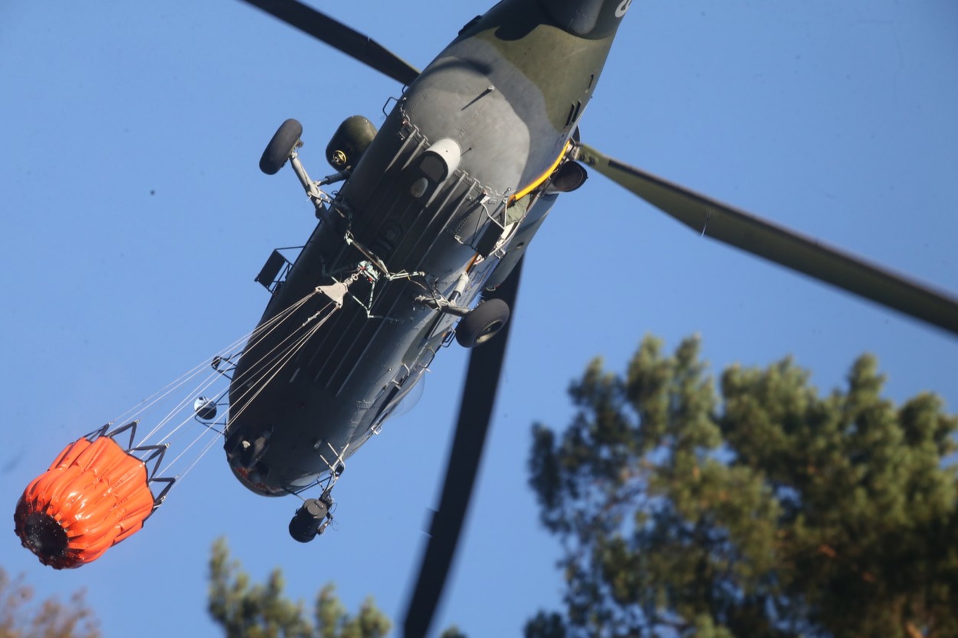 Vrtulník nabírá vodu z Labe do bambi vaku.