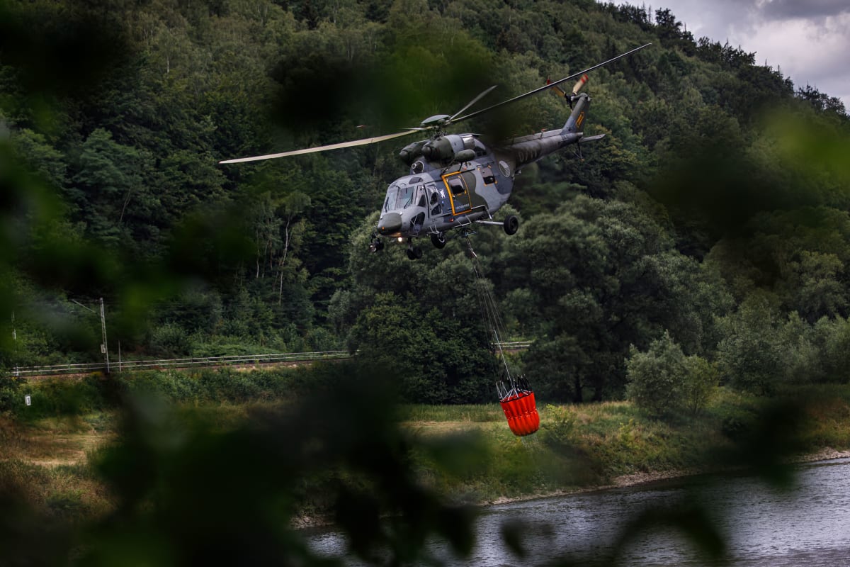 Do akce jsou zapojeny i vrtulníky, které oheň kropí vodou.