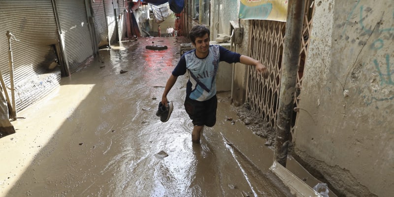 Muž se brodí v bahně po bleskových záplavách v severozápadní části Teheránu v Íránu, čtvrtek 28. července 2022. 