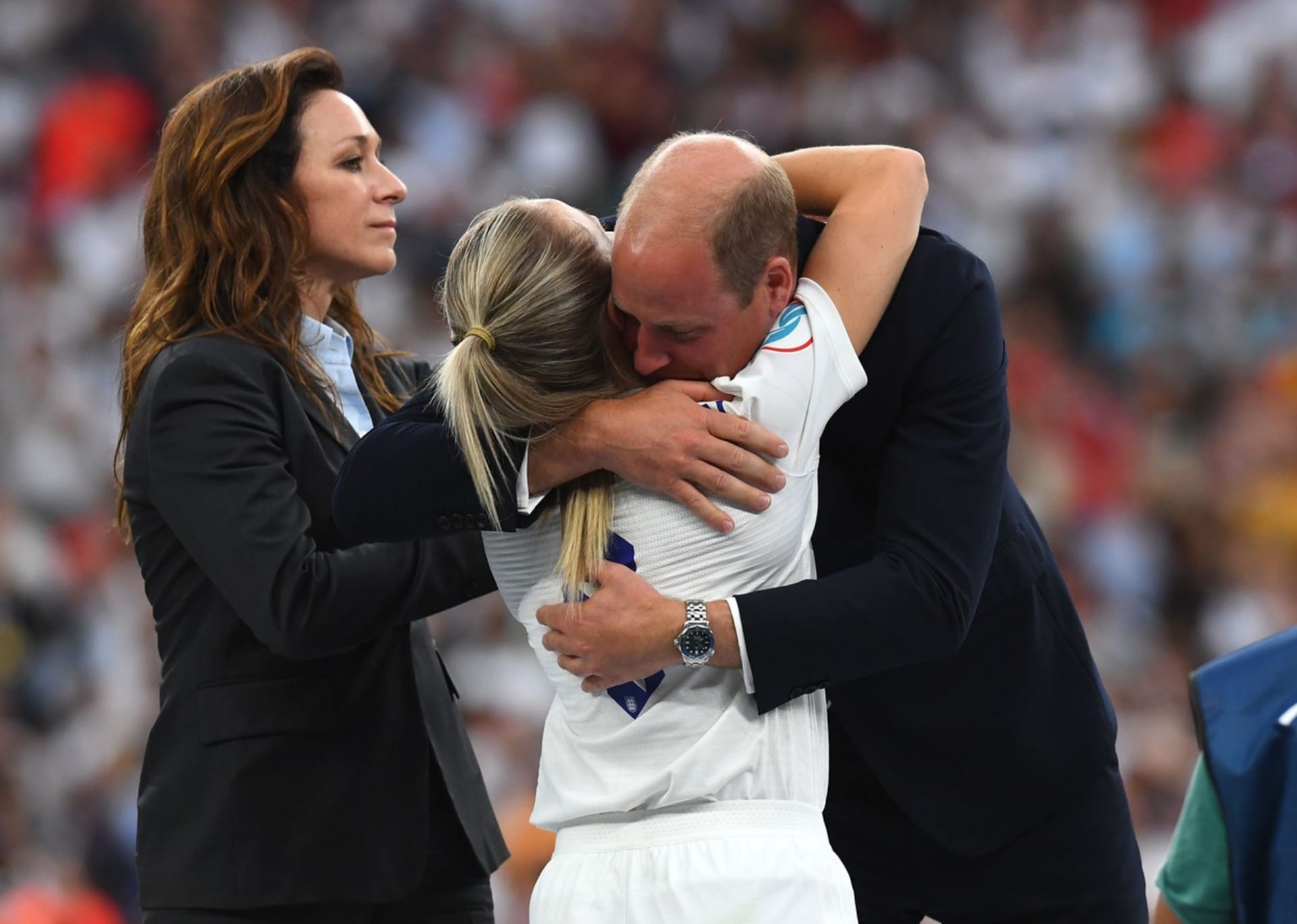 Princ William objímá kapitánku anglické fotbalové reprezentace Leah Williamsonovou na stupních vítězů po finále mistrovství Evropy na stadionu Wembley v Londýně. 