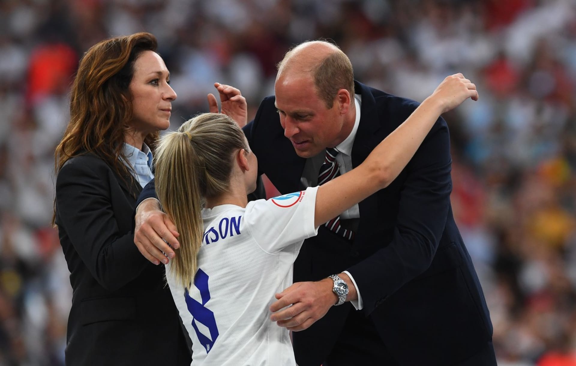 Princ William se chystá obejmout kapitánku anglické fotbalové reprezentace Leah Williamsonovou na stupních vítězů po finále mistrovství Evropy na stadionu Wembley v Londýně. 