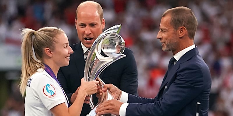 Kapitánka anglické reprezentace Leah Williamsonová přebírá pod dohledem prince Williama trofej pro fotbalové mistryně Evropy z rukou prezidenta Evropské fotbalové unie Aleksandera Čeferina (vpravo).