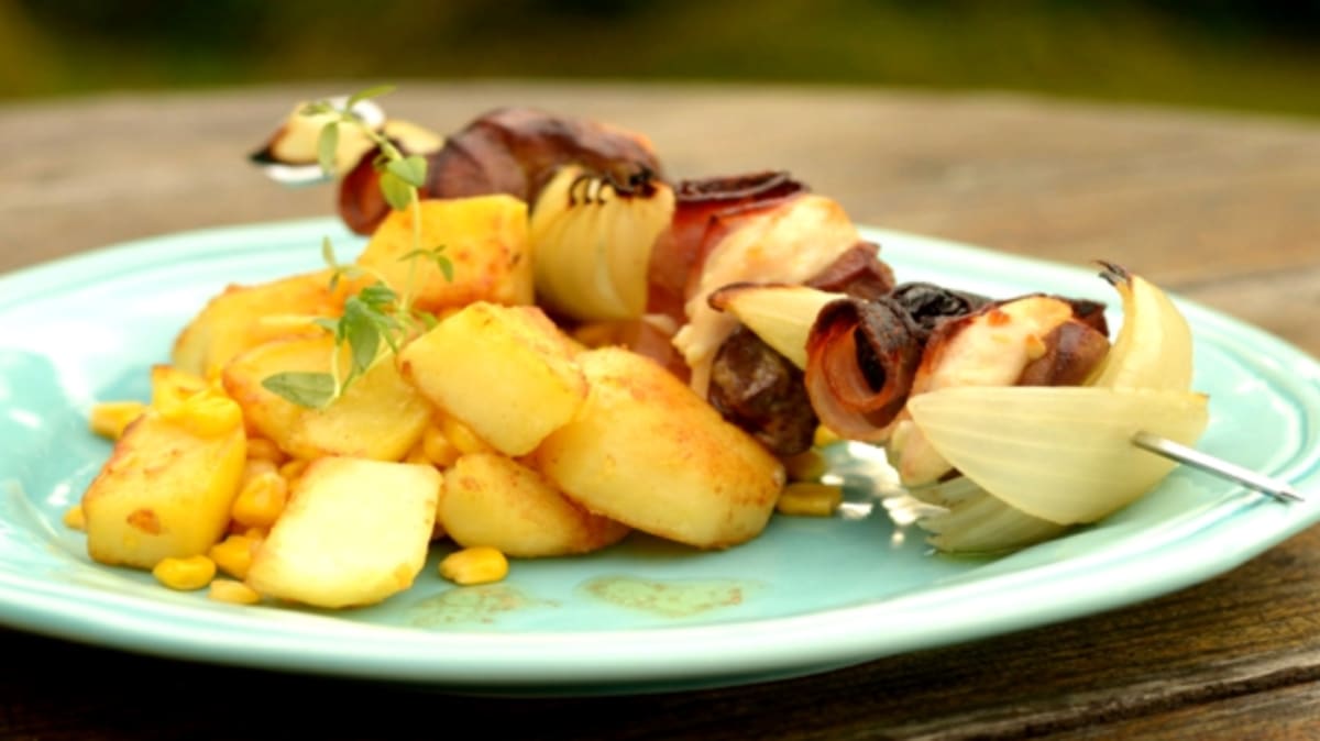 Kuřecí špíz se sušenými švestkami a slaninou a máslové brambory s kukuřicí