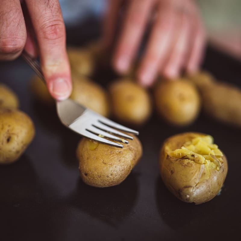 Uvařené brambory dejte na plech a zmáčkněte je vidličkou na placičky