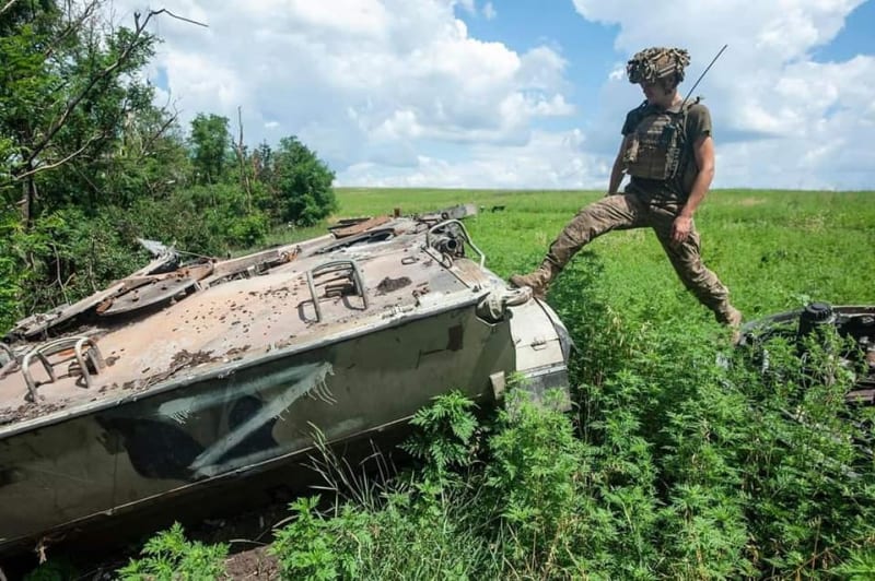 Člen ukrajinské 93. mechanizované brigády postává u zničeného ruského obrněnce.