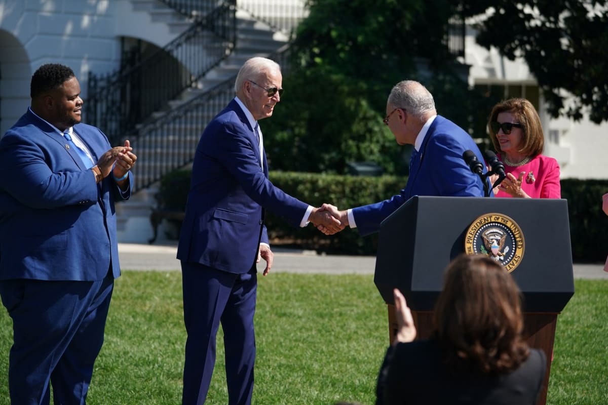 Joe Biden si podává ruku s Chuckem Schumerem (9. 8. 2022).