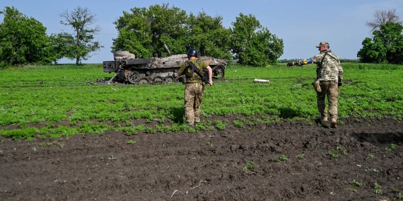 Ukrajinští vojáci stojí u zničeného ruského obrněnce. (31. května)