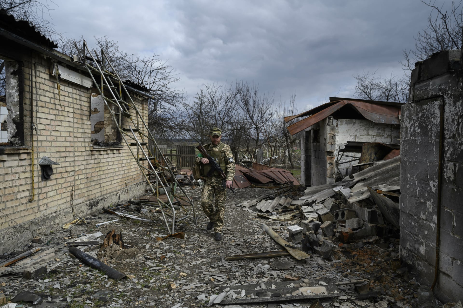 Ukrajinský voják mezi troskami v Andriivce