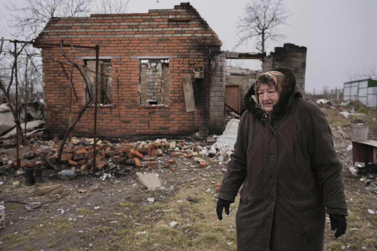 Žena před troskami domu v Andriivce