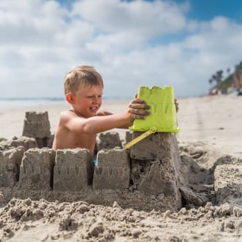 Chlapec staví hrad z písku