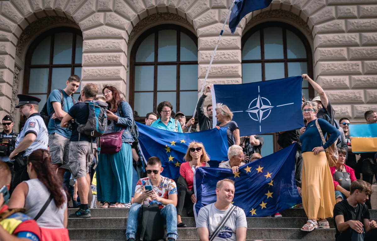 Na schodech Národního muza si skupinka podporovatelů současné vlády vytvořilo improvizované stanoviště a sledovali demonstraci se vztyčenými vlajkami Evropské unie a Severoatlantické aliance. 