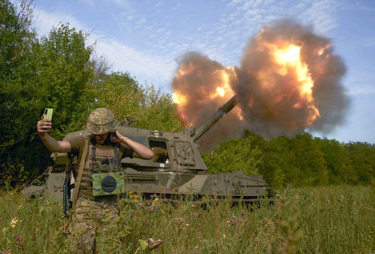 Ukrajinský voják se fotí u dělostřelecké palby v Doněcké oblasti. (3. září 2022)