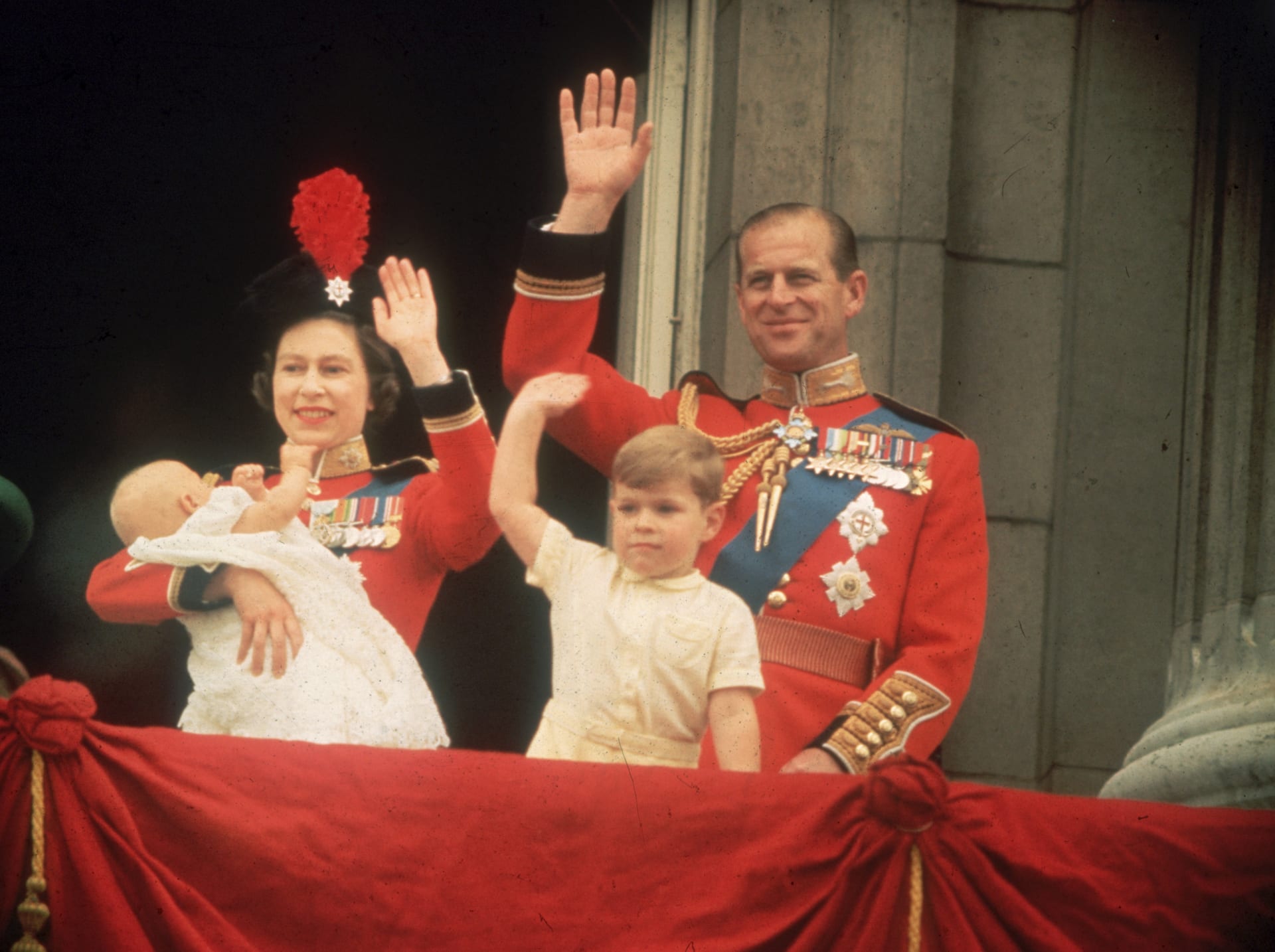 Královna Alžběta II. se svým manželem princem Philipem na ikonickém balkóně v Buckinghamském paláci. S nimi jejich dvě děti, princ Andrew a princ Edward (1964)