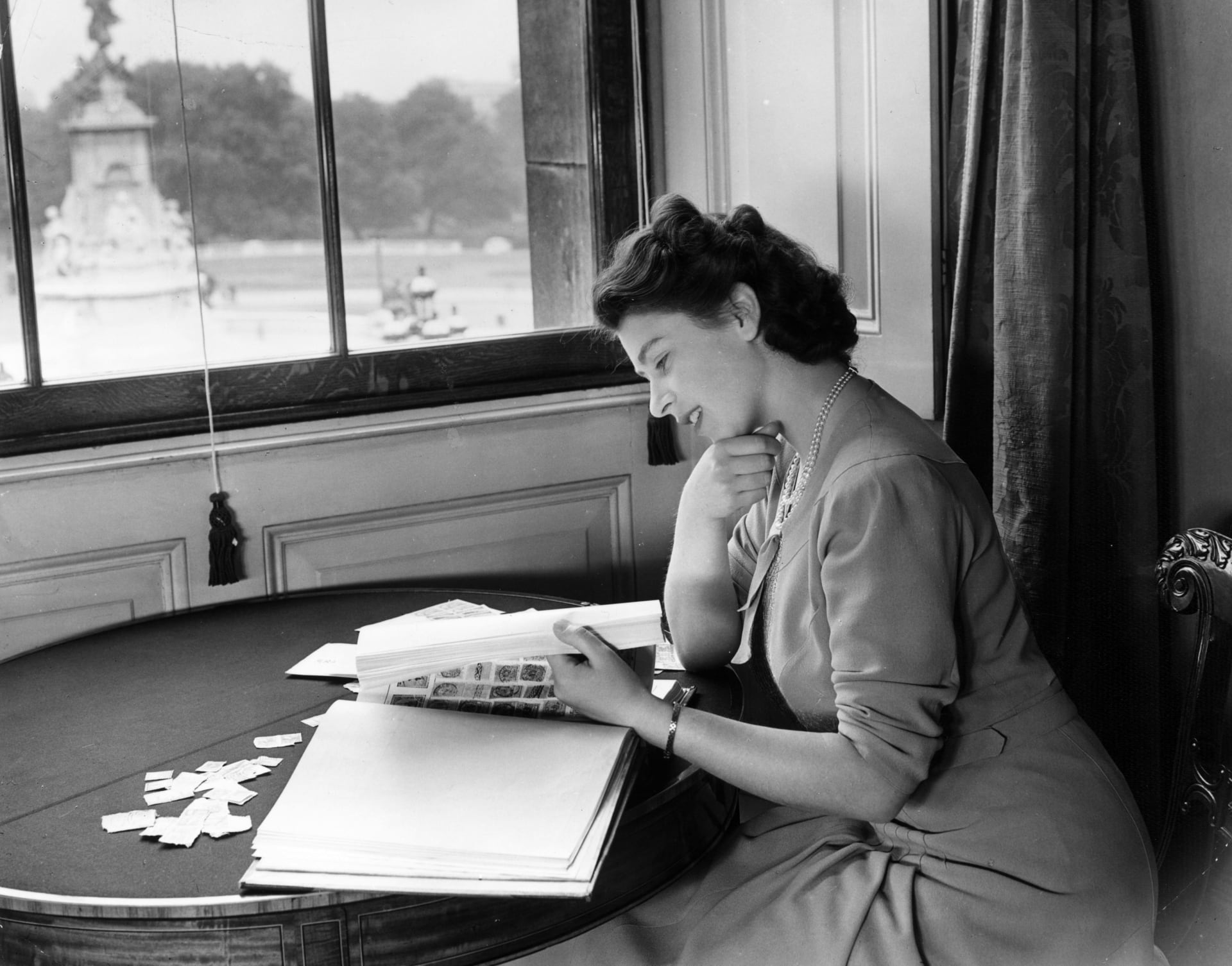 Princezna Alžběta si prohlíží svou sbírku známek ve státních apartmánech Buckinghamského paláce. (1946)