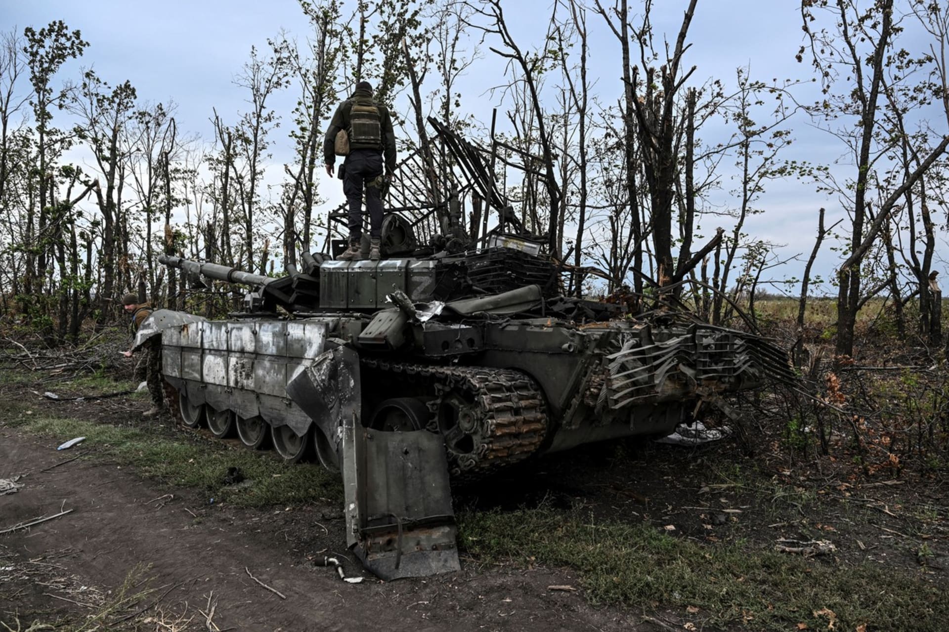 Ukrajinský voják stojí na opuštěném ruském tanku poblíž města Izjum v Charkovské oblasti