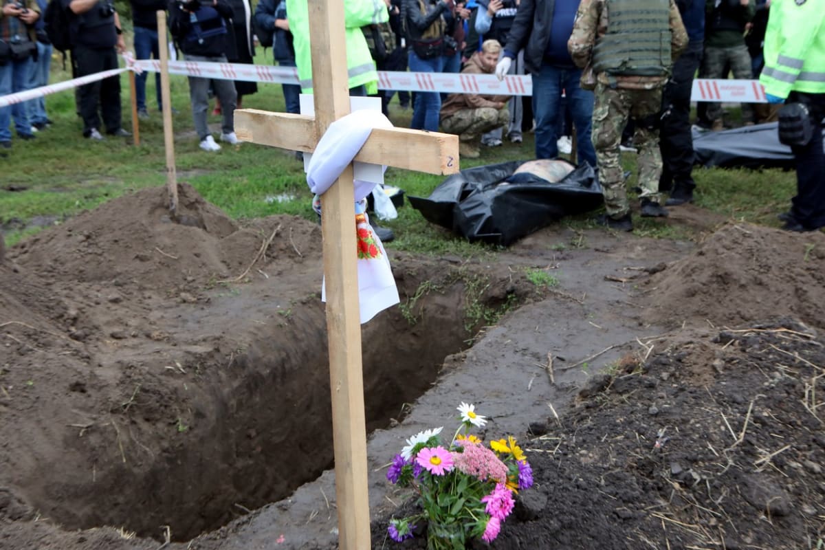 Forenzní experti zkoumají tělo zastřeleného civilisty v Ukrajinci osvobozeném městě Balaklija v Charkovské oblasti