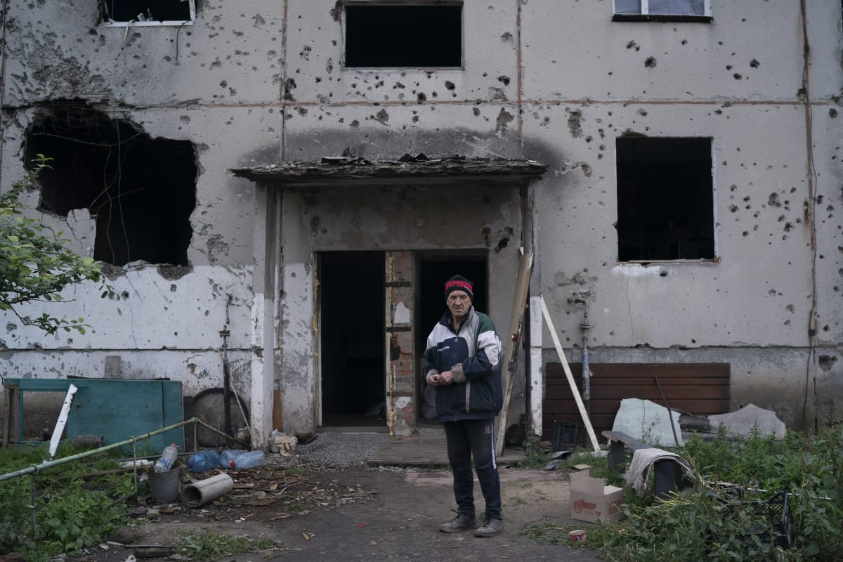 Muž stojí před zničeným domem v Ukrajinci osvobozené obci Harkove v Charkovské oblasti