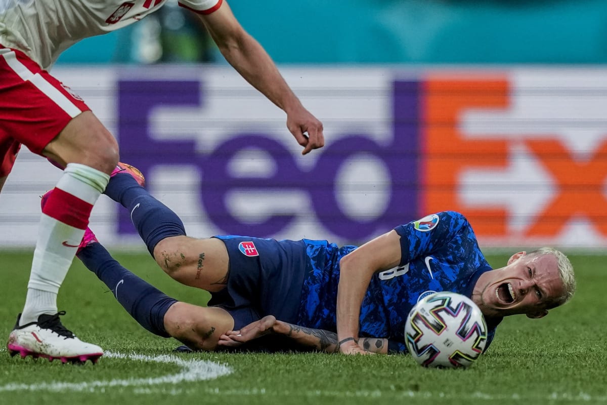 Slovenský záložník Ondrej Duda křičí bolestí po faulu během utkání mistrovství Evropy 2021 proti Polsku. 