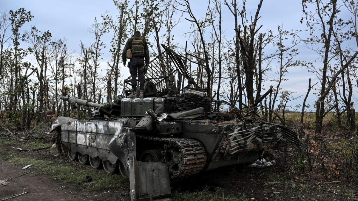 Ukrajinský voják stojí na opuštěném ruském tanku poblíž města Izjum v Charkovské oblasti