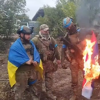 Ukrajinští vojáci pálí ruskou vlajku v osvobozeném městě Volčansk v Charkovské oblasti