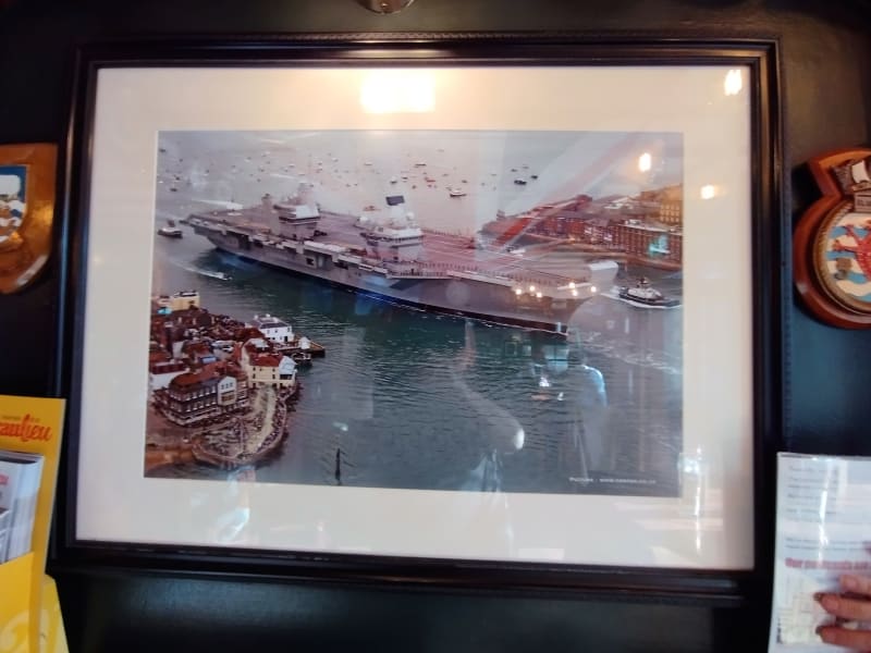 Na pintě piva s královnou. Výčep The Ship Anson v Portsmouthu. Ve výčepu je snímek letadlové lodě Queen Elizabeth, jež kotví v Portsmouthu.