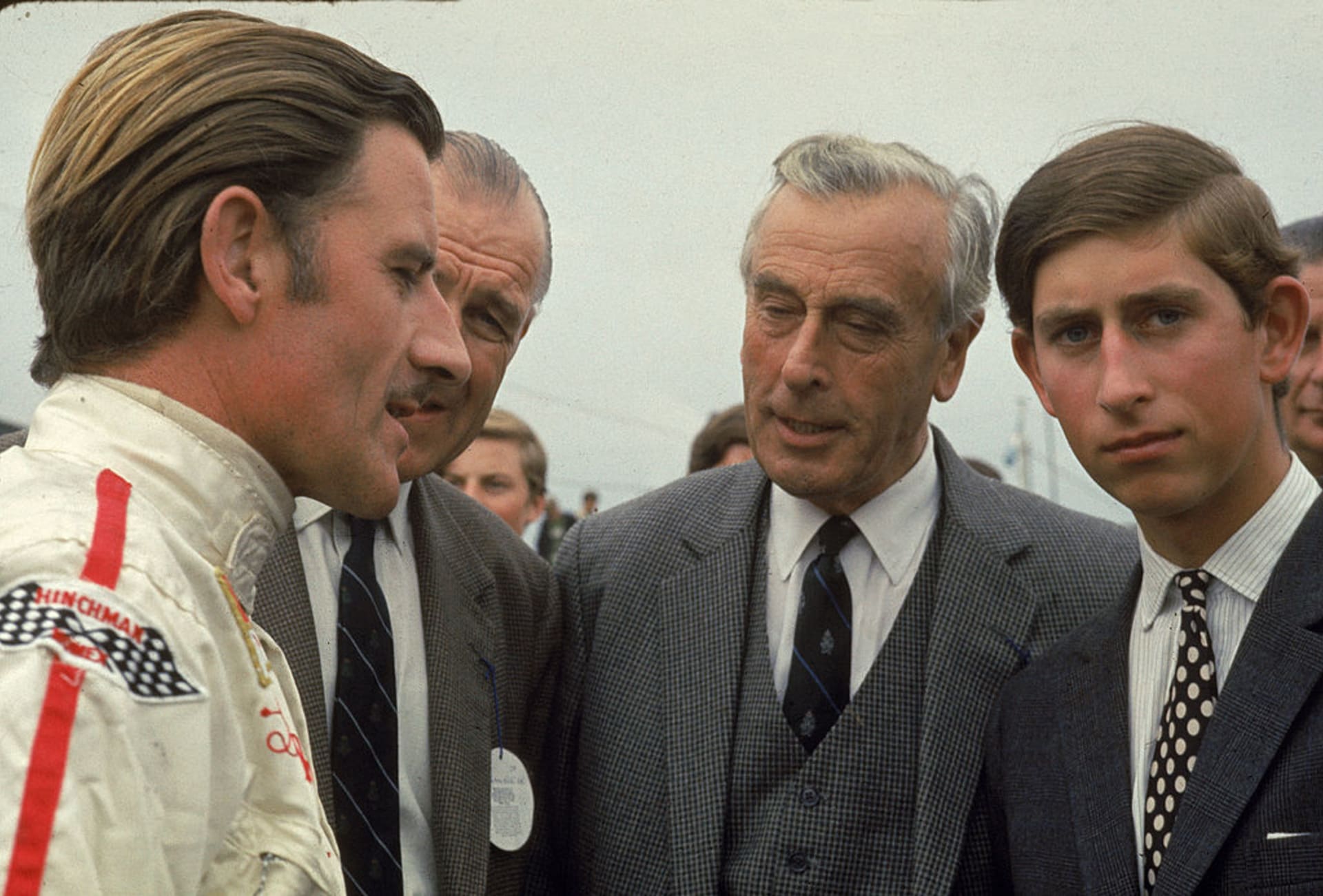 S Grahamem Hillem, legendárním britským jezdcem formule 1. Charlesovi dával lekce rychlé jízdy, naslouchá i Lord Mountbatten (uprostřed).