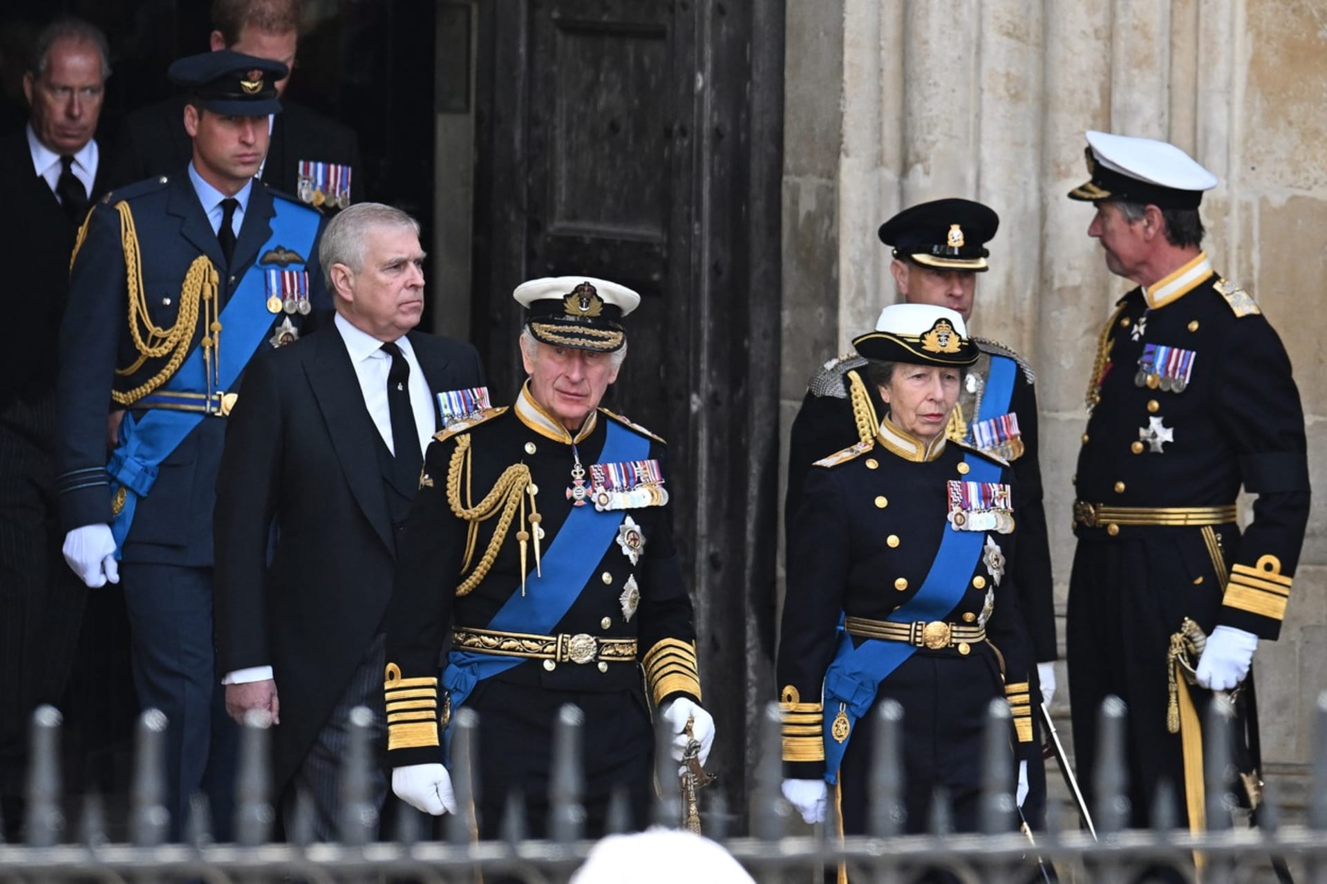 Princ Andrew a princezna Anna stojící vedle krále Karla III. 