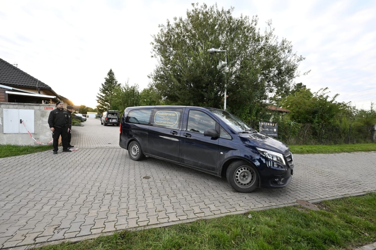 Vůz pohřebního ústavu u rodinného domu v Měšicích u Prahy, kde byli nalezeni čtyři mrtví lidé.