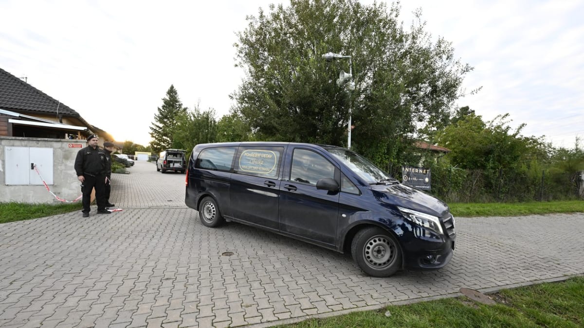 Vůz pohřebního ústavu u rodinného domu v Měšicích u Prahy, kde byli nalezeni čtyři mrtví lidé.