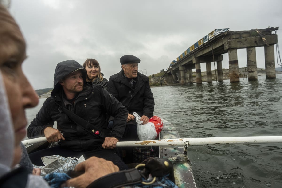 Kvůli zničenému mostu u města Staryj Saltov musí lidé přes řeku Severní Doněc na člunu