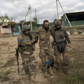 Ukrajinští vojáci pomáhají zraněnému kolegovi u znovudobyté obce Ščurove v Doněcké oblasti