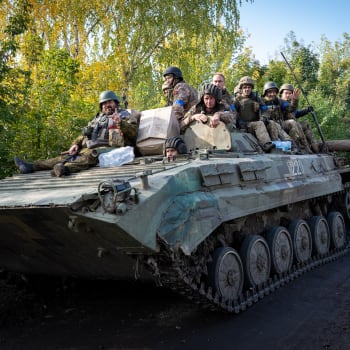 Ukrajinský obrněný transportér převáží vojáky k pontonovému mostu přes řeku Oskil 30. září 2022 v Kupjansku na Ukrajině.