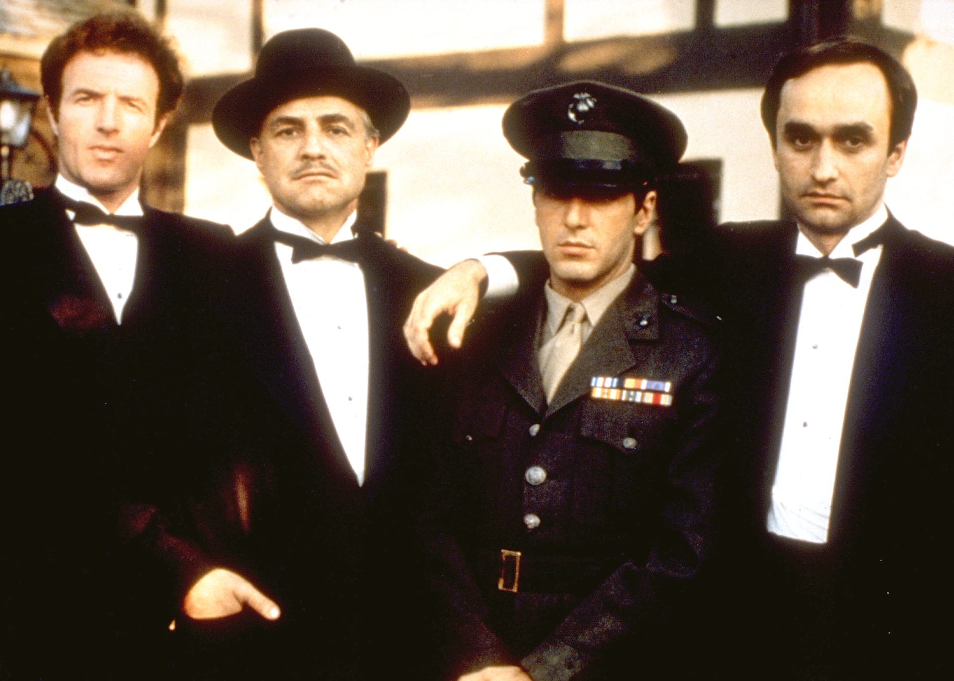 Don Vito Corleone (Marlon Brando, druhý zleva) a jeho synové. Zleva Sonny (James Caan), Michael (Al Pacino) a Fredo (John Cazale).