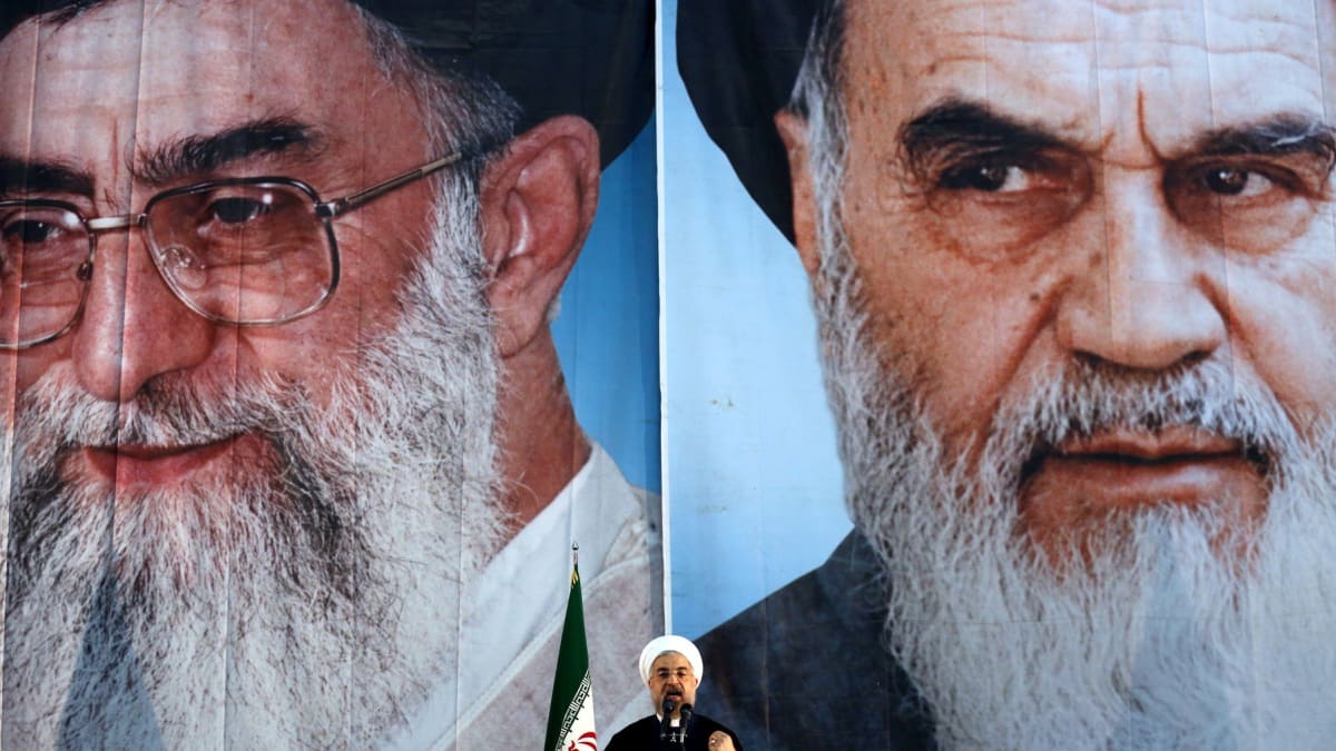 Trojice velkých hráčů: Současný prezident Íránu Hasan Rúhání před portréty Sajjida Alí Chameneího (vlevo) a Rúholláha Chomejního.