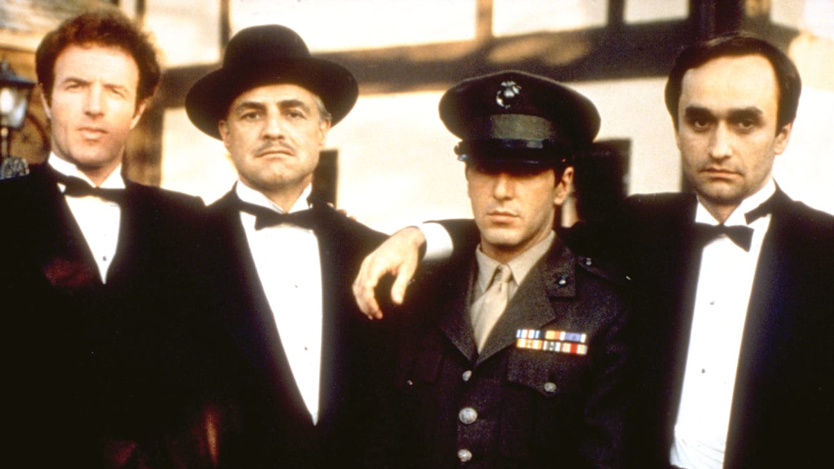 Don Vito Corleone (Marlon Brando, druhý zleva) a jeho synové. Zleva Sonny (James Caan), Michael (Al Pacino) a Fredo (John Cazale).